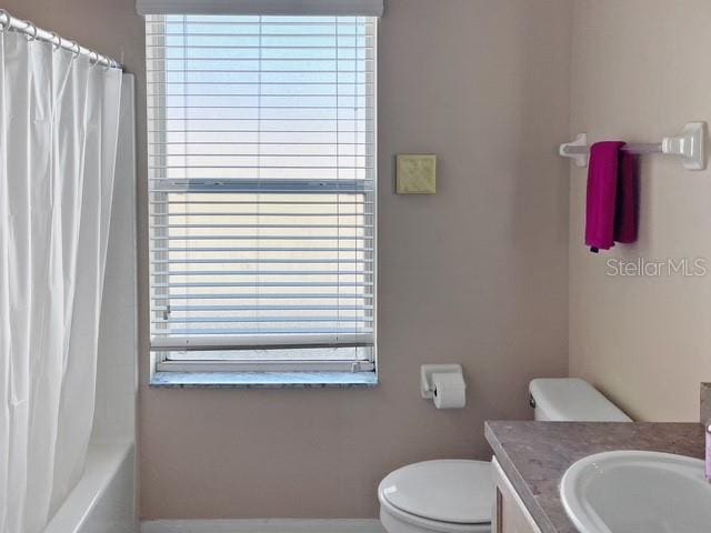 full bathroom with vanity, toilet, a wealth of natural light, and shower / tub combo