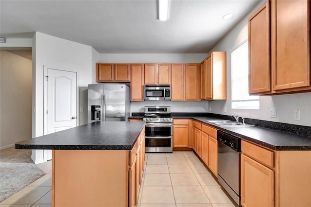 kitchen featuring a kitchen island, sink, light tile patterned floors, and stainless steel appliances