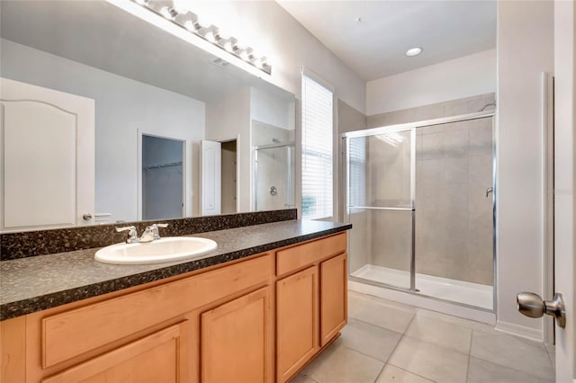 bathroom featuring tile patterned flooring, vanity, and a shower with shower door