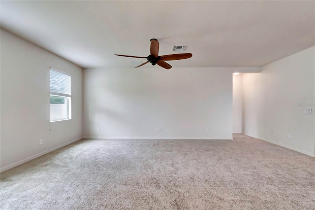 carpeted spare room featuring ceiling fan