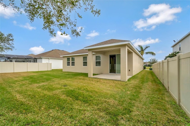 back of house featuring a lawn and a patio area