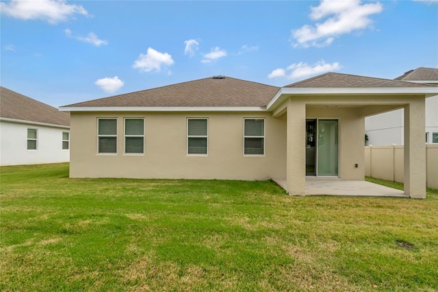 rear view of house with a patio and a lawn