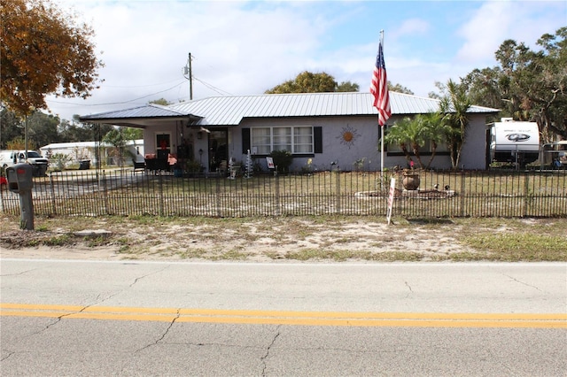 ranch-style home featuring a carport and a front yard