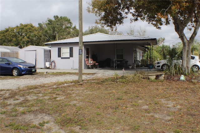 back of house featuring a shed and a carport