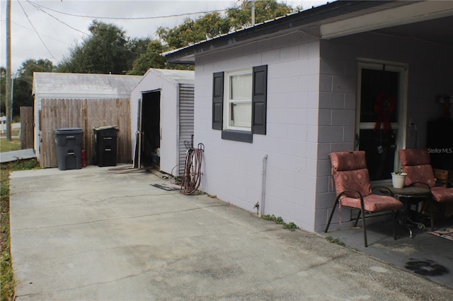 view of side of home featuring a patio area and a storage unit