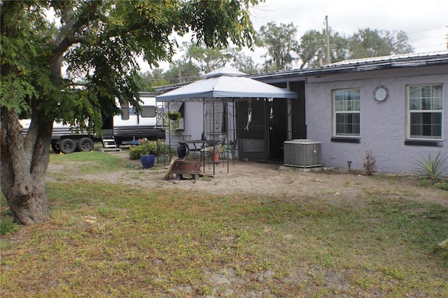 back of house with a gazebo, a yard, and cooling unit