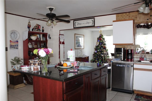 kitchen with light tile patterned flooring, sink, dishwasher, a kitchen island, and ceiling fan