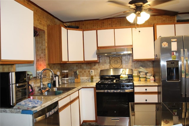 kitchen featuring backsplash, under cabinet range hood, appliances with stainless steel finishes, white cabinets, and a sink