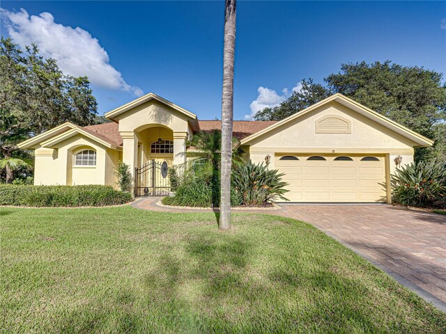 1072 Old Cutler Rd, Lake Wales, FL 33898 - mediterranean / spanish home featuring stucco siding, a front lawn, decorative driveway, and a garage