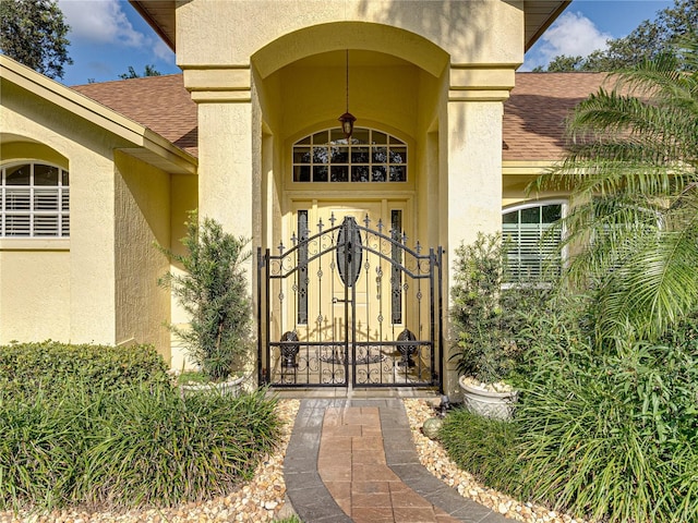 1072 Old Cutler Rd, Lake Wales, FL 33898 - property entrance with roof with shingles, stucco siding, and a gate