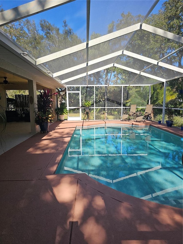 view of swimming pool with glass enclosure and a patio area