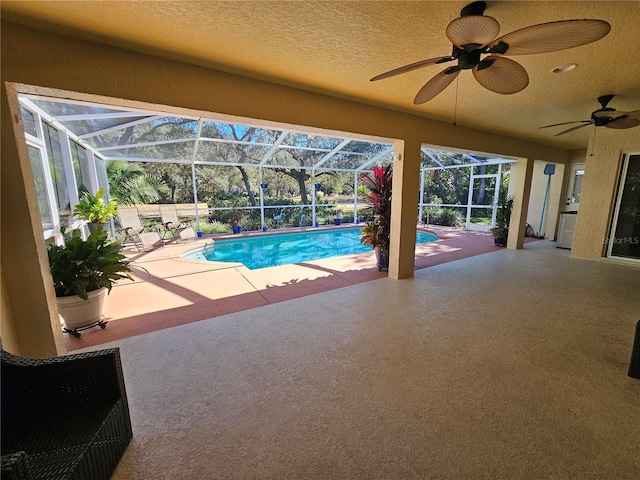 view of pool featuring a patio, ceiling fan, and a lanai