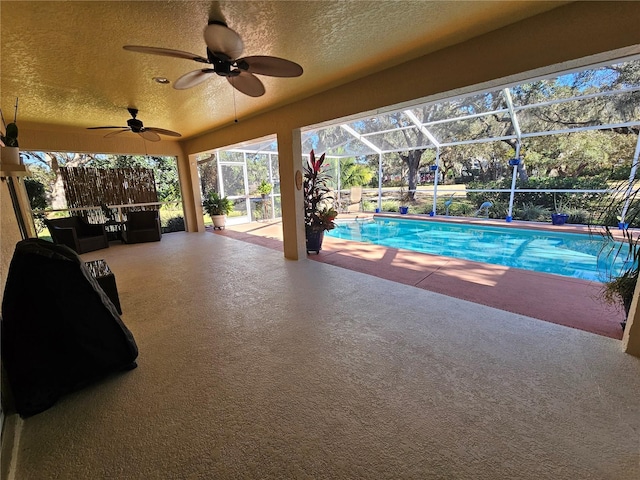 view of swimming pool with a lanai, ceiling fan, and a patio