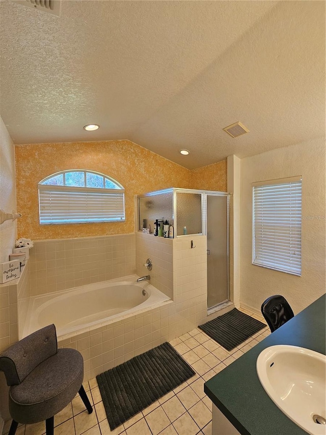 bathroom featuring vaulted ceiling, tile patterned flooring, a shower with shower door, and a textured ceiling