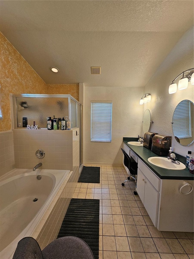 bathroom with tile patterned flooring, vanity, a textured ceiling, and shower with separate bathtub