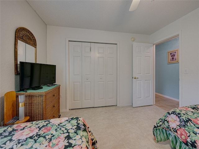 tiled bedroom featuring ceiling fan, a textured ceiling, and a closet