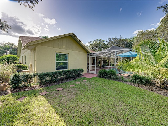 back of house featuring a lanai and a yard