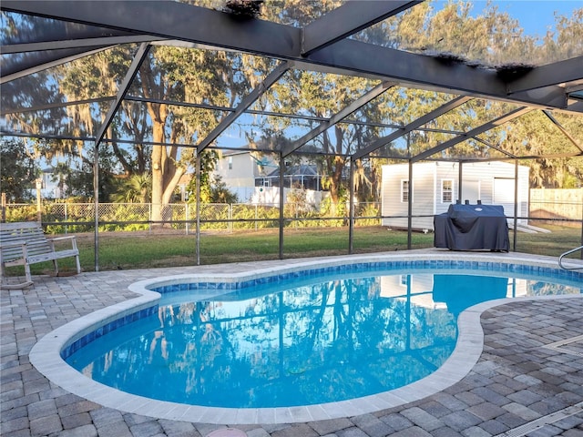 view of pool featuring a storage unit, area for grilling, a patio, and glass enclosure