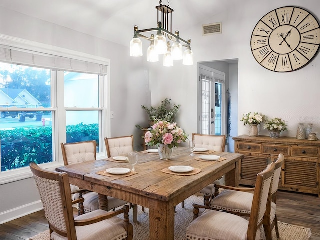 dining area featuring lofted ceiling, dark hardwood / wood-style floors, and a notable chandelier