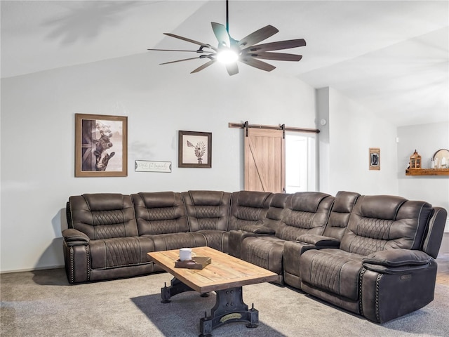 living room with a barn door, carpet, and vaulted ceiling