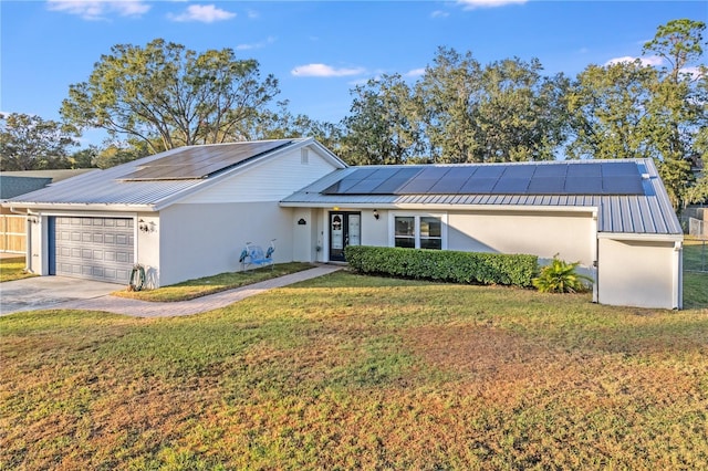 ranch-style house with solar panels, a garage, and a front lawn