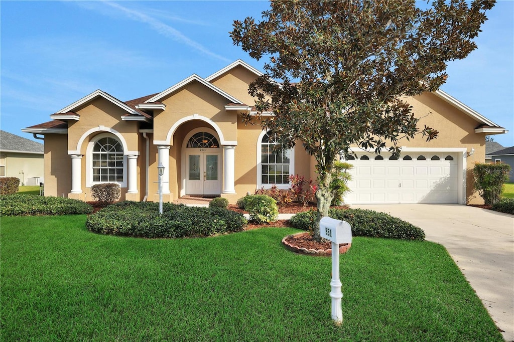 single story home with french doors, a front yard, and a garage