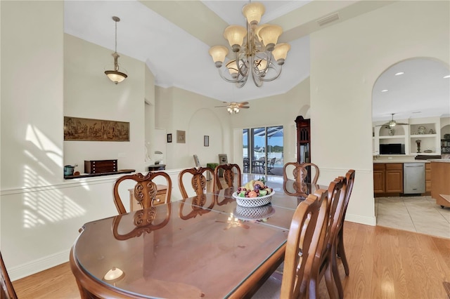 dining area featuring built in features, light hardwood / wood-style floors, and ceiling fan with notable chandelier