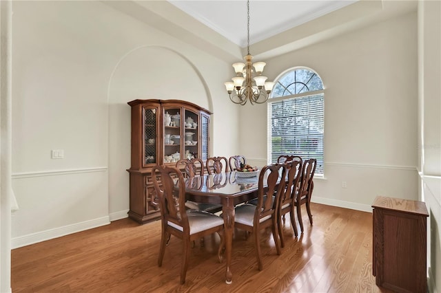 dining room featuring hardwood / wood-style floors, ornamental molding, and an inviting chandelier