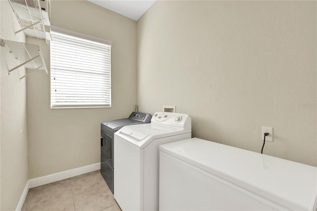 washroom with separate washer and dryer and light tile patterned flooring