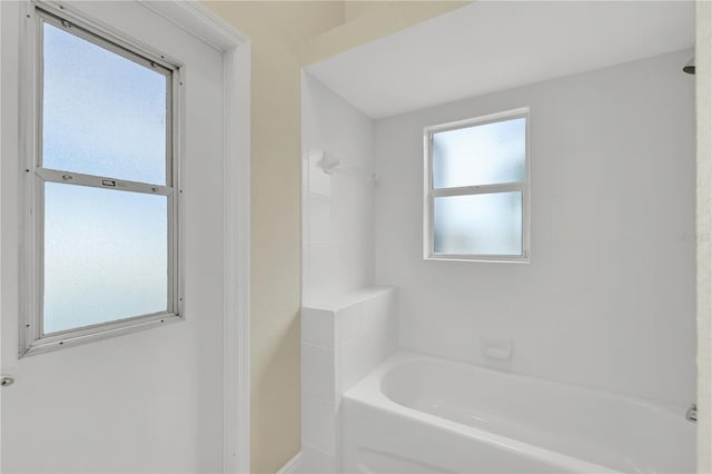 bathroom with plenty of natural light and a tub