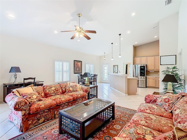 living room featuring ceiling fan, light tile patterned flooring, sink, and vaulted ceiling