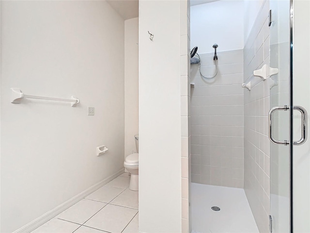 bathroom with tile patterned floors, toilet, and an enclosed shower