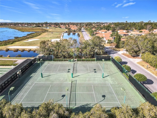 view of tennis court with a water view