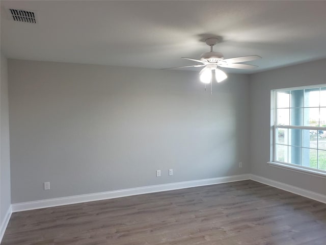 spare room with dark hardwood / wood-style flooring and ceiling fan