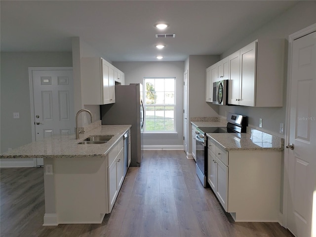 kitchen with white cabinets, sink, wood-type flooring, and stainless steel appliances