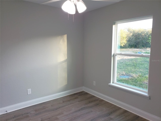 unfurnished room with ceiling fan and dark wood-type flooring