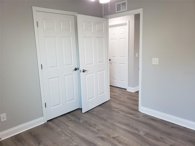 unfurnished bedroom featuring a closet and wood-type flooring