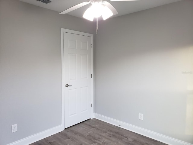 empty room with ceiling fan and dark wood-type flooring