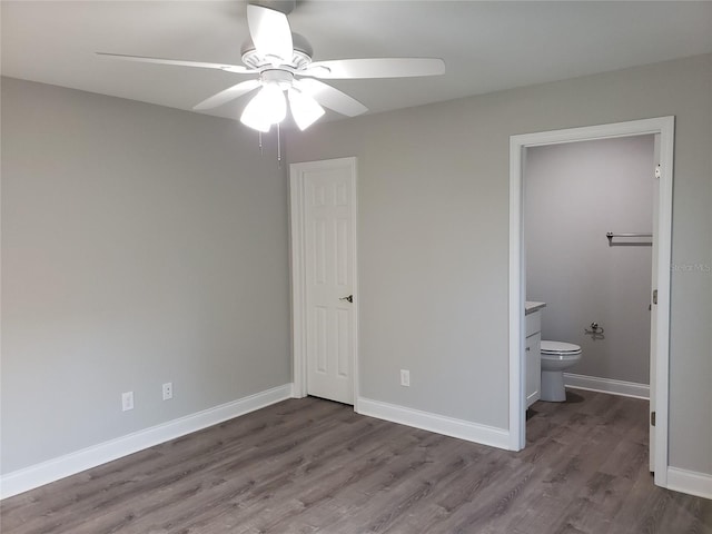 unfurnished bedroom featuring wood-type flooring, ensuite bath, and ceiling fan