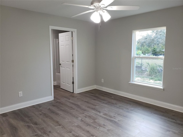 unfurnished room with dark hardwood / wood-style flooring and ceiling fan