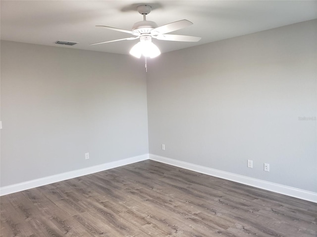 empty room featuring dark hardwood / wood-style flooring and ceiling fan