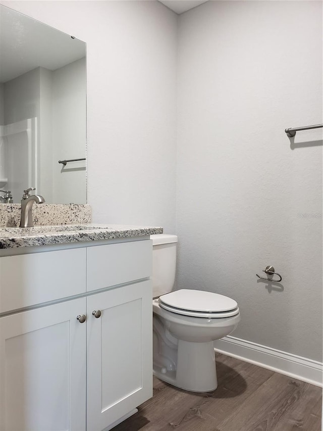 bathroom featuring hardwood / wood-style floors, vanity, and toilet