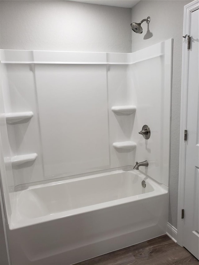 bathroom with shower / bathtub combination and hardwood / wood-style flooring