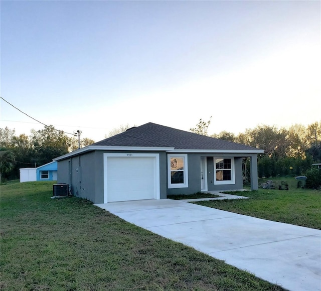 ranch-style home featuring central AC unit, a front yard, and a garage