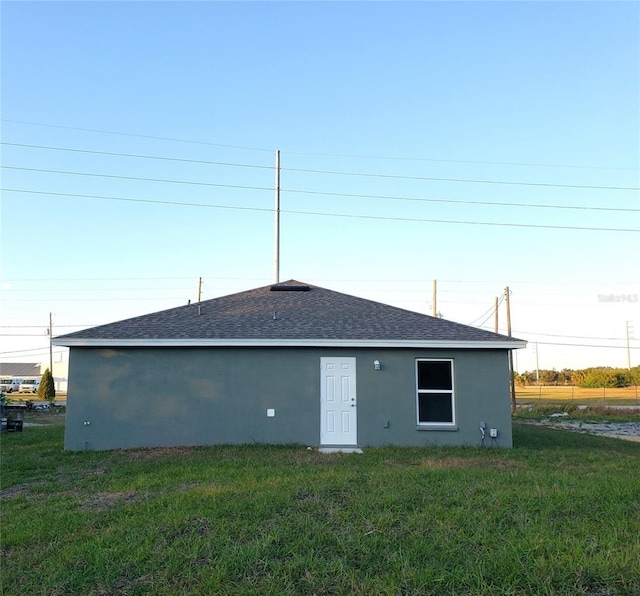 rear view of property featuring a lawn