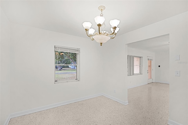 1891 18th St NW, Winter Haven, FL 33881 - spare room with a chandelier and speckle patterned floor