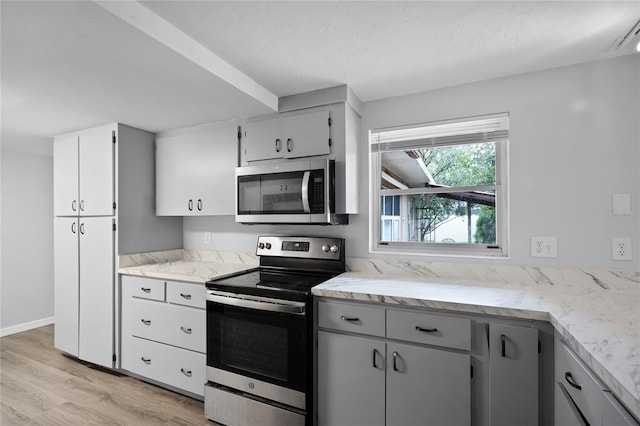 1891 18th St NW, Winter Haven, FL 33881 - kitchen featuring appliances with stainless steel finishes, light wood-type flooring, and light stone counters