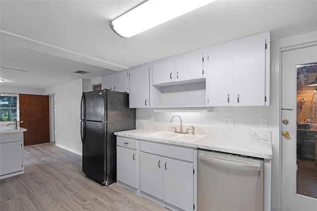 1891 18th St NW, Winter Haven, FL 33881 - kitchen with stainless steel dishwasher, freestanding refrigerator, light countertops, light wood finished floors, and open shelves