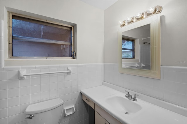 bathroom featuring vanity, toilet, and tile walls