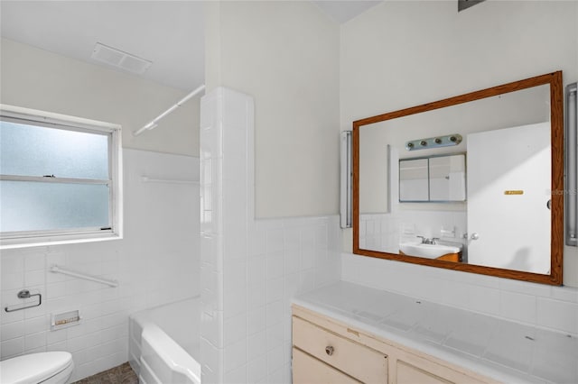 full bathroom with shower / bathing tub combination, vanity, toilet, and tile walls